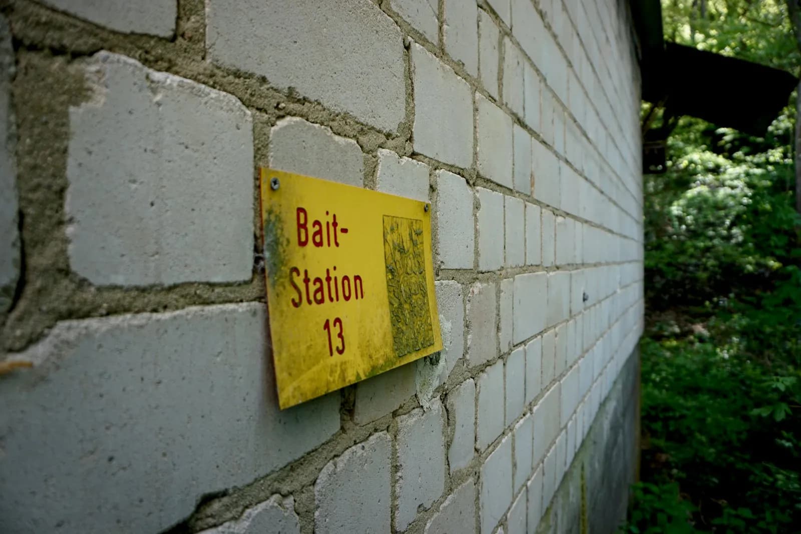 Tabliczka oznaczająca stację z przynętą na ścianie budynku